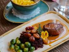 Piatto di selvaggina autunnale con carne, castagne, cavoletti di Bruxelles e cavolo rosso