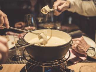 Diverse persone si godono una fonduta di formaggio