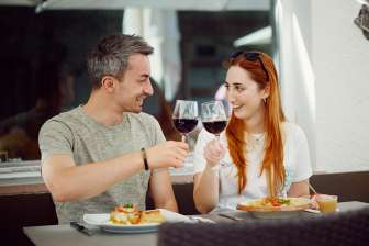 Una coppia brinda con del vino rosso, piatto principale al ristorante Chrüz © Hannes Heinzer