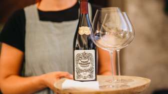 Servizio vino Castel Salenegg Donna che serve una bottiglia di vino con bicchieri