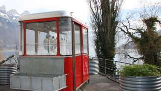 Gondola per fonduta sul lago di Walen Una gondola rossa trasformata in ristorante di fonduta si trova sulla riva del lago di Walen.