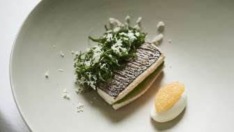 Filetto di coregone elegantemente servito su un piatto bianco