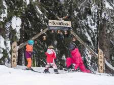 Due bambini e una donna all'ingresso della pista avventura sul Flumserberg