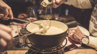 Diverse persone si godono una fonduta di formaggio