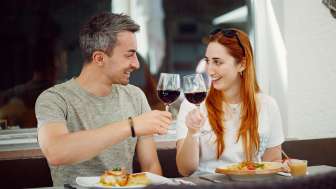 Una coppia brinda con del vino rosso, piatto principale al ristorante Chrüz © Hannes Heinzer